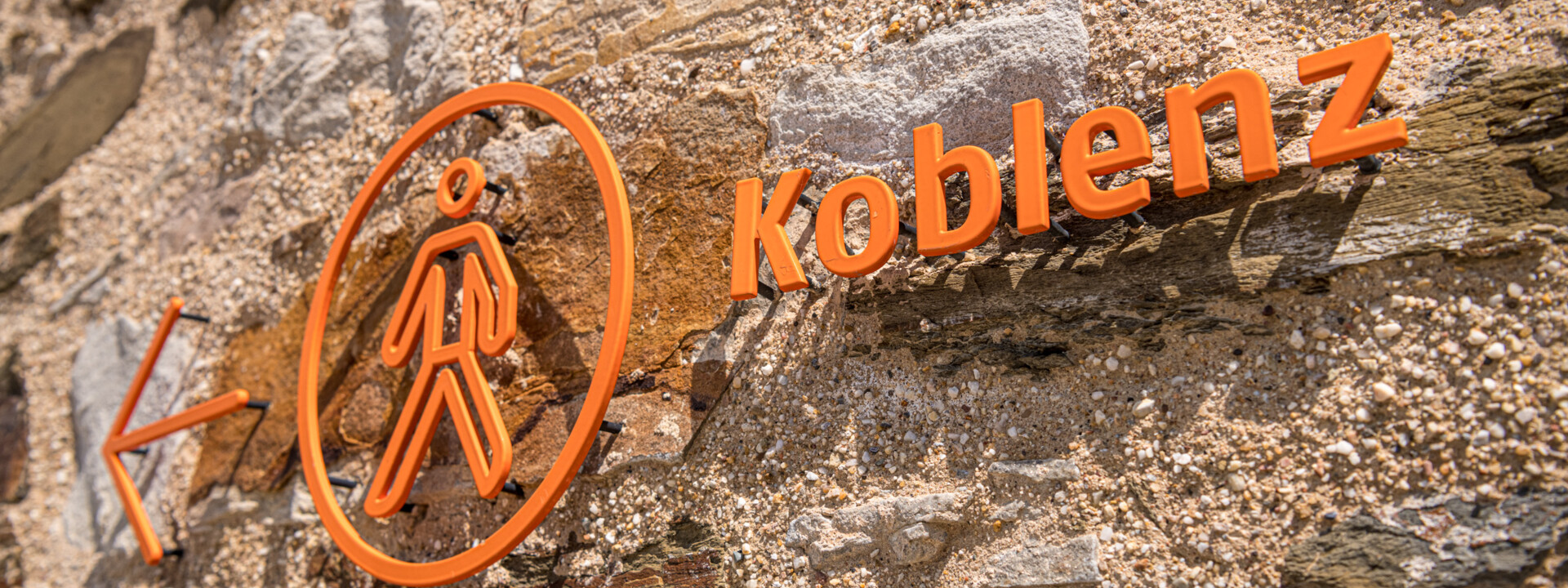 Koblenzschild an Mauer mit Pfeil in Richtung Stadt © Koblenz-Touristik GmbH, Dominik Ketz Koblenzschild an Mauer mit Pfeil in Richtung Stadt © Koblenz-Touristik GmbH, Dominik Ketz